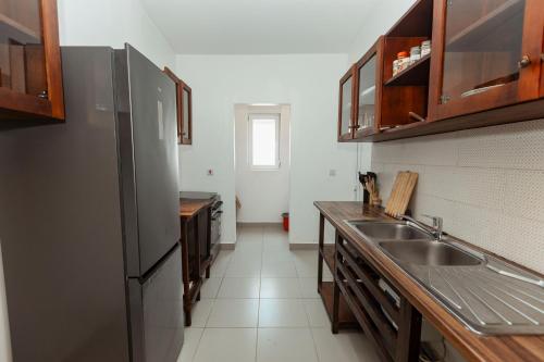 a kitchen with a stainless steel refrigerator and a sink at Smile Homes in Zanzibar City
