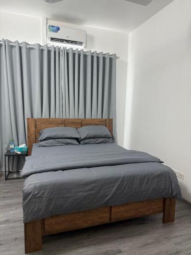 ein Schlafzimmer mit einem Holzbett mit einem Vorhang in der Unterkunft Coral Stay Rooms in Hulhumale