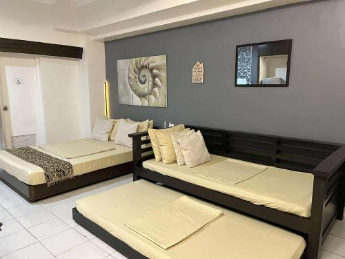 ein Schlafzimmer mit zwei Betten und einem Spiegel in der Unterkunft City Land Tagaytay Prime in Ulot