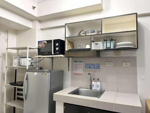 eine kleine Küche mit Spüle und Kühlschrank in der Unterkunft City Land Tagaytay Prime in Ulot