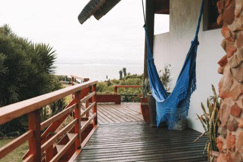 a porch with a hammock and a view of the ocean at Dreamland Beach House & Studios at Supertubes in Jeffreys Bay