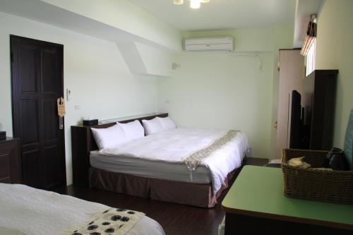 a bedroom with two beds and a green table at Magi House in Magong