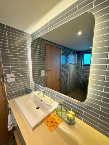 a bathroom with a sink and a large mirror at B89 3BR Hillside Seaview Escape in Ban Ko Kok