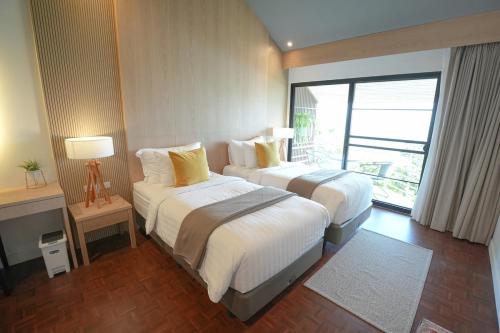 a hotel room with two beds and a large window at B89 3BR Hillside Seaview Escape in Ban Ko Kok