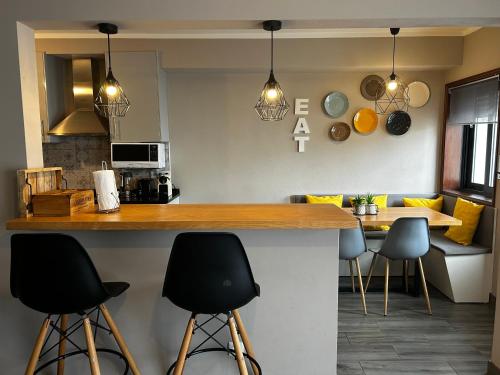 a kitchen with a counter with stools and a table at The Lighthouse Apartment in Praia da Barra