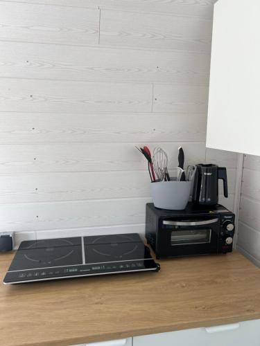 a kitchen counter with a toaster oven and a microwave at Bauwagen in Fanø