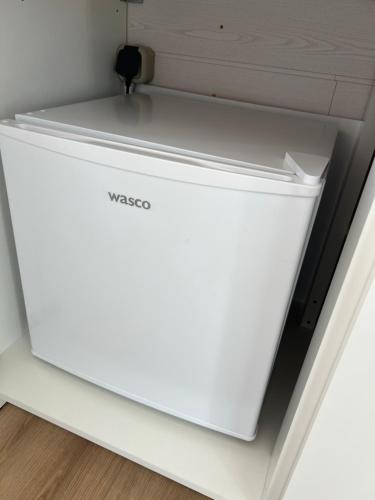 a white refrigerator sitting in a room at Bauwagen in Fanø