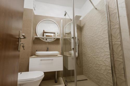 a bathroom with a shower and a toilet and a mirror at APARTAMENT de LUX SIBIU in Sibiu