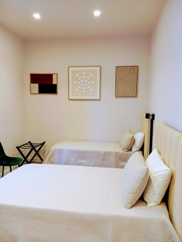 a bedroom with two beds and a chair at Nocera House in Nocera Inferiore