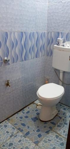a bathroom with a white toilet and blue tiles at Royal properties thika jomoko in Thika