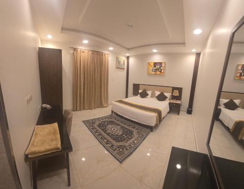 a hotel room with two beds and a rug at امواج الشرق للشقق المخدومه in Khamis Mushayt
