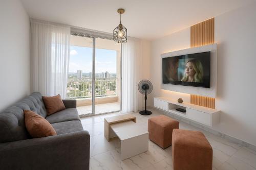 Una sala de estar con un sofá y un televisor. en APARTAMENTO FAMIliar MELGAR, en Melgar