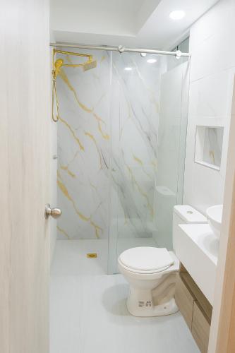 a bathroom with a toilet and a glass shower at APARTAMENTO FAMIliar MELGAR v in Melgar