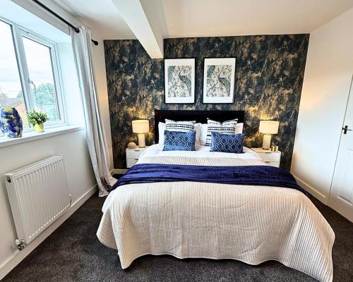 a bedroom with a large bed with blue pillows at Cosy Staff, Large 6-bedroom Detached house in Whitwick