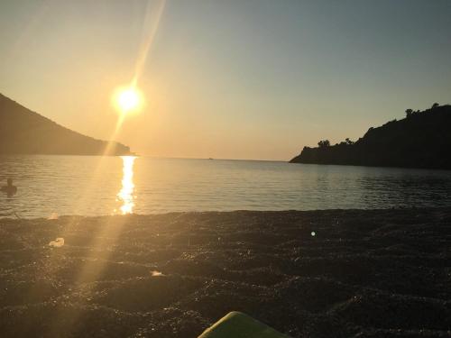 a sun setting over a body of water at Hotel Pelagos Studios in Platána