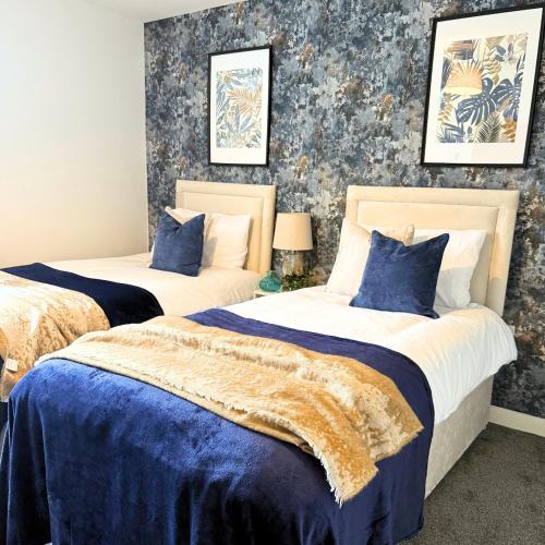 two beds in a bedroom with blue and white at Cosy Staff, Large 6-bedroom Detached house in Whitwick