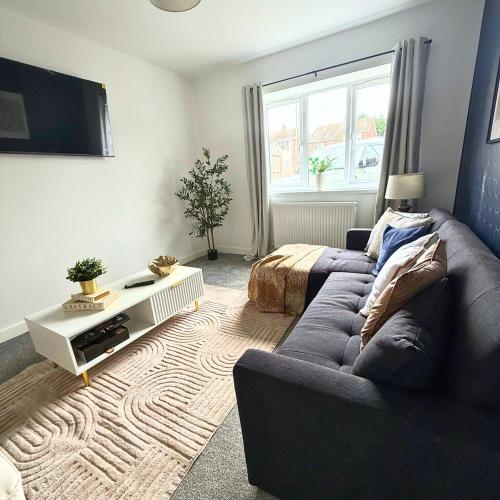 a living room with a couch and a tv at Cosy Staff, Large 6-bedroom Detached house in Whitwick