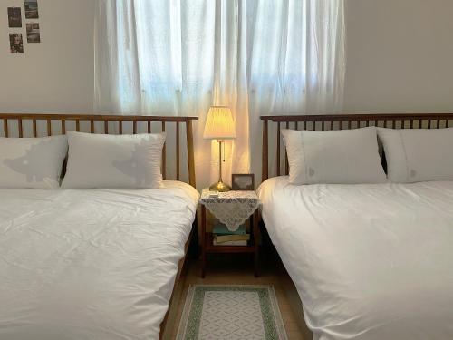 two beds sitting next to each other in a bedroom at 들락스테이 Deullak Stay in Millak-tong