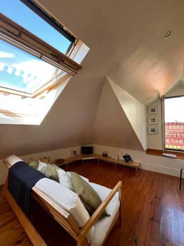 a living room with a bed and a large window at Inglesinhas in Lisbon