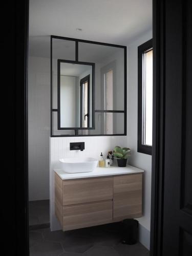 een badkamer met een witte wastafel en een spiegel bij Royal in Cococodji