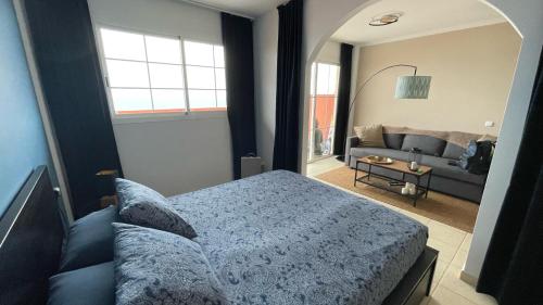 Un dormitorio con una cama y una sala de estar. en Besonderes Apartment mit einzigartigem Meerblick, en Costa Calma