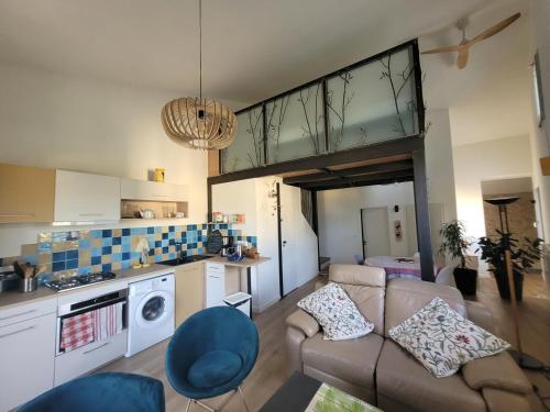 un salon avec un canapé et une cuisine dans l'établissement La chouette paisible, à Villecroze