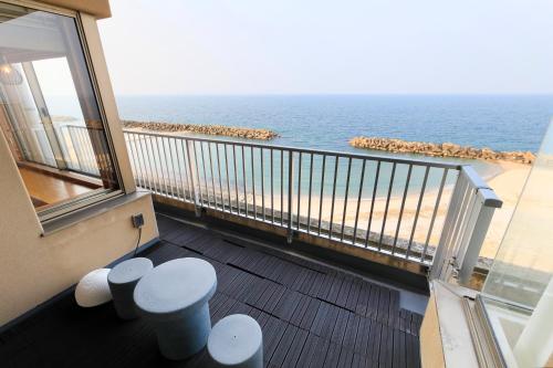 a balcony with a view of the beach at Yukibou Hakusen in Yonago