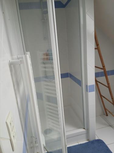 una ducha con puerta de cristal en un baño en Chambre étudiant, en Coutances