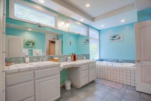 a bathroom with two sinks and a tub and a mirror at GrandView in Encinitas