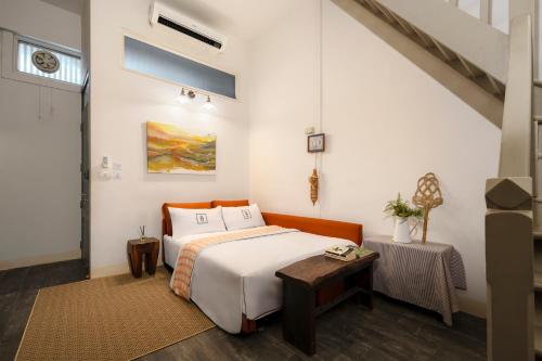 a bedroom with a bed and a table at Non Inn Entire Historic 5 Bedroom Riverside Shophouse near ICONSIAM for Families and Groups in Bang Rak