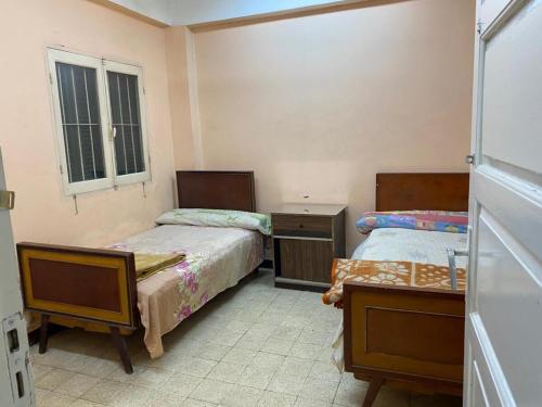 a bedroom with two beds and a window at Nile Cruise Aswan in Luxor