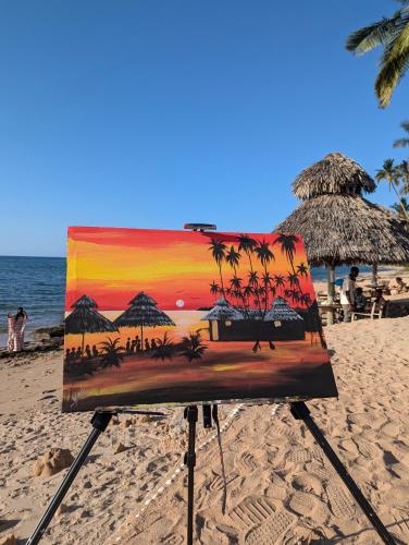 AFLII Beach Resorts Msangamkuu في متوارا: لوحة لشاطئ مع مظلات والمحيط