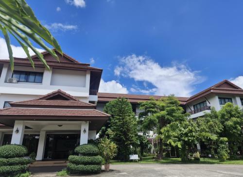 a building with trees in front of it at Wilacha Chiang Rai in Chiang Rai
