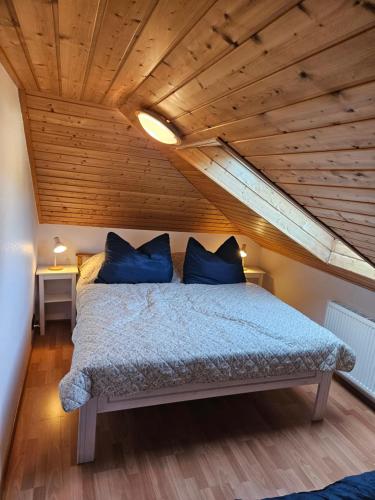 a bedroom with a bed with blue pillows at Apartmán Sofie Mariánské Lázně in Mariánské Lázně