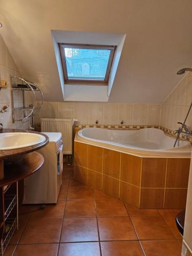 a bathroom with a large tub and a sink at Apartmán Sofie Mariánské Lázně in Mariánské Lázně