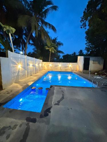 a swimming pool at night with lights on it at De Dreams beach in Puducherry