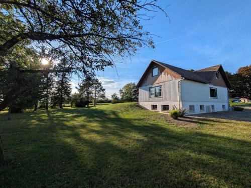 a house on a grassy field with a tree at Maison de location in La Malmaison