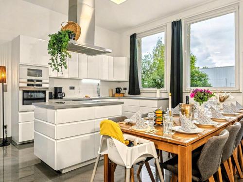 ニュルンベルクにあるScandi Loft für bis zu 12, Whirlpool, Sauna, Gaming, Nordstadtの部屋に木製のテーブルと椅子が置かれたキッチン