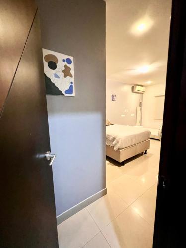a bedroom with a bed and a door with a painting at Samborondón Luxury Room by Adriana in SamborondÃ³n