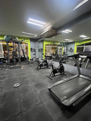 a gym with several treadmills and elliptical machines at Samborondón Luxury Room by Adriana in SamborondÃ³n