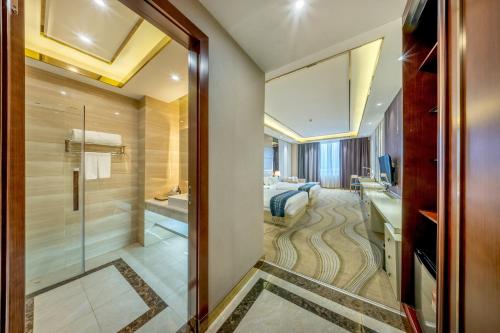 a bathroom with a shower and a sink and a bed at ST Hotel Wattay Airport in Vientiane
