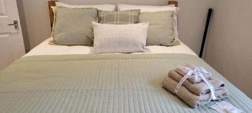 a bed with a blanket and pillows on it at Rūm by the beach in Camber