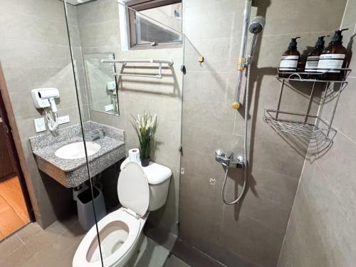 a bathroom with a toilet and a sink and a shower at Destiny Hotel - 1601 in Manila