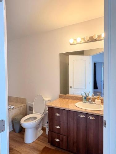 a bathroom with a toilet and a sink at Maison Acropole in Gatineau