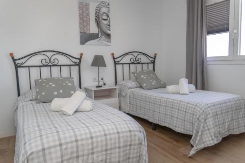 a bedroom with two beds and a statue of a woman at Apartamento Rincón de la calma in Alcudia