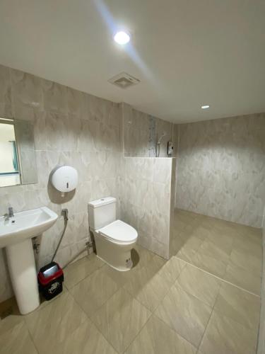 a bathroom with a white toilet and a sink at Pun's Garden Home in Ban Sao Thong