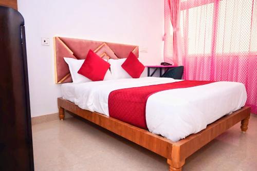 a bedroom with a bed with red and white pillows at Pandooi Prasth, Patna in Patna