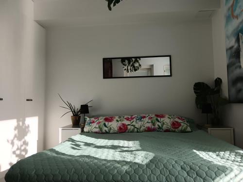 a bedroom with a bed with a green comforter and a mirror at King's Oak Jungle in Helsinki
