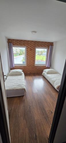 two beds in a room with two windows at Chmurka in Górno
