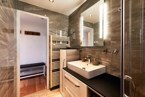a bathroom with a sink and a glass shower at Elegant 3BD Holiday Home in Prime Location of Vienna in Vienna